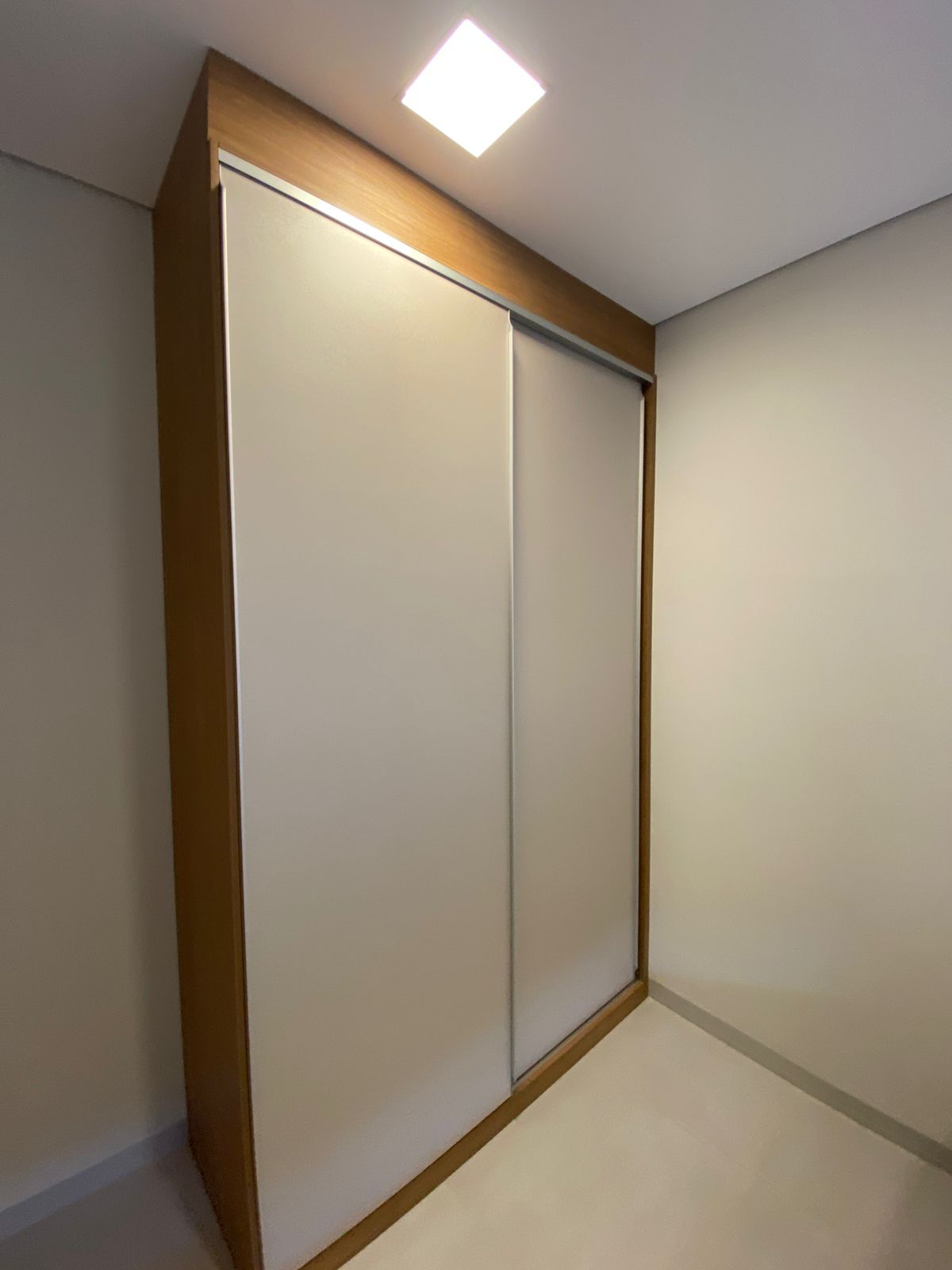 Guarda-roupa planejado com portas de correr abertas, cabideiro e prateleiras internas