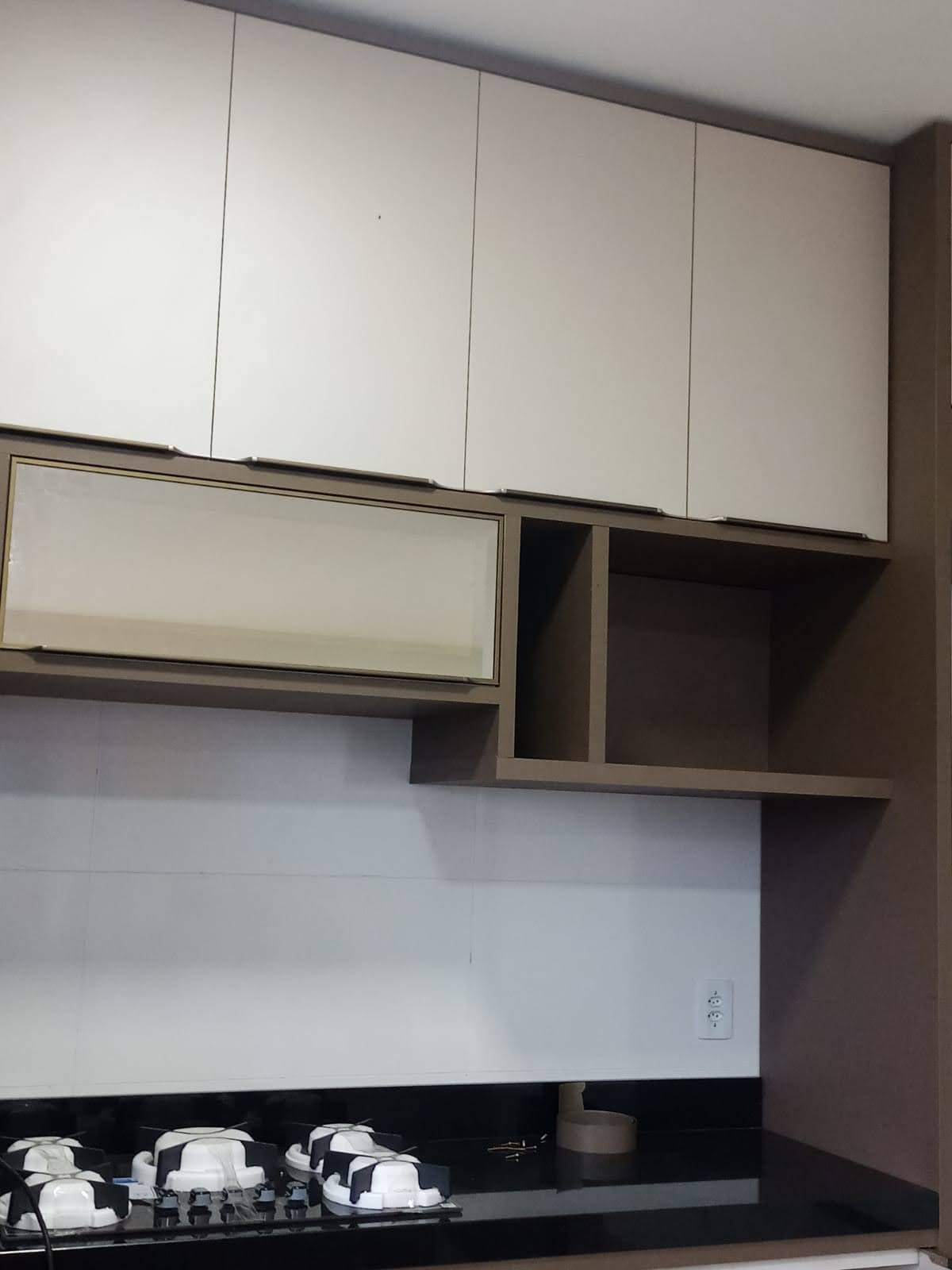 Cozinha planejada com armários superiores e inferiores, torre de eletrodomésticos e bancada clara